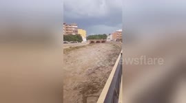 Overflowing river transports tonnes of debris following heavy rainstorm in southern Spain