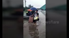 Hero elderly man rows residents across flooded road