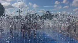 Kids playing in the fountains outdoors in the evening sun at the Southbank centre london