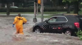 Firefighter wades through knee-high waters to rescue driver stuck in flash flood