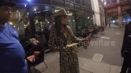 Lorraine Chase hands sweets to photographers