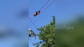Orangutan mum helps baby cross rope line at Washington zoo