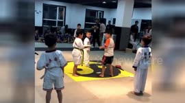 Boy helps friend break planks after his roundhouse kick fails