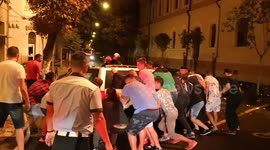 Members of public move car as Romanian palace burns