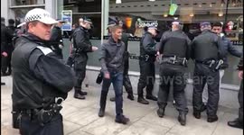 Police detain men outside Caffe Nero during Notting Hill Carnival
