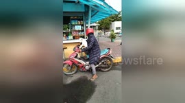 Nervous dog leaps onto back of master's motorbike