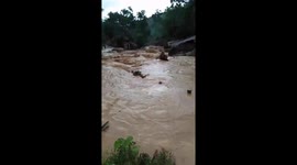The moment of flood water destroyed the bridge and swept away many houses in the village