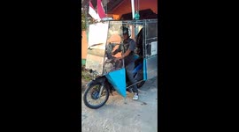 Easy drier! Moped rider keeps family out of rain in bizarre contraption