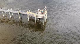 Guys jump off pier into water