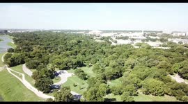 Magic pro 4K of a river some buildings and trees next to a highway