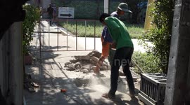 Man operates a jack hammer in his bare feet.