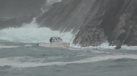 Motor boat in trouble by a strong wave.Motora en apuros cojida por una ola