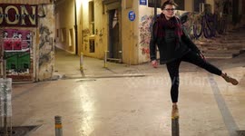 Cute girl balancing on a pole in the street
