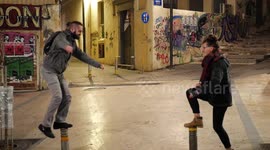 Girl and guy balancing on two poles