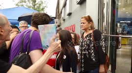 Alexandria Ocasio-Cortez waits to pose for pictures at Queens rally
