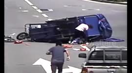 Passersby lift up three-wheeler to rescue trapped cyclist