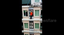 Workman in Thailand casually fixes air con seven floors up without a harness