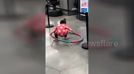 Toddler tries in vain to pick up Hula Hoop