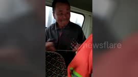 Passenger wipes windscreen by hand in moving car