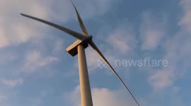 A windmill turbine, under a blue sky.