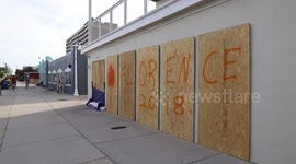 N. Carolina Coast: Cyclists pass boarded up windows that say “Florence 2018”