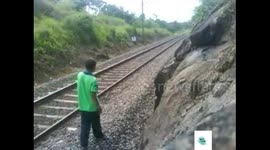 Man lays down on a railway track while a train speeds over him