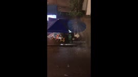 Street food seller picked the wrong spot... under a 'waterfall'