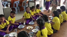 Thai school children eat lunch at Rama 9 temple Bangkok