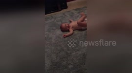 Diapered baby attempts his first somersaults all by himself
