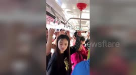 Chinese woman uses plunger as a makeshift handle on bus