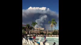 Huge pyrocumulus cloud from Charlie Fire looms above pool-splashing families at Six Flags