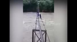 Students cross flooded river using shaky pipeline in India