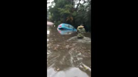 Elderly lady trapped in waist high flood water rescued by onlookers