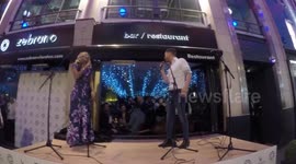 British ex-soap actress Gemma Oaten smiles in the face of microphone failure at karaoke