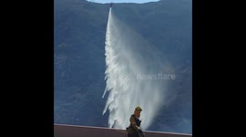 Helicopter conducts water drop on 50-acre brush fire near Cajon Pass, Southern California