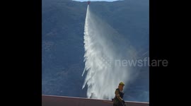 Helicopter conducts water drop on 50-acre brush fire near Cajon Pass, Southern California