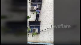 Man scales third-floor window to hold up trapped toddler for 20 minutes