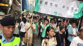 Joshua Wong walks under the Demosistō banner at the National march in Hong Kong