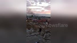 Palu residents stare at still-smoking ruins morning after magnitude 7.4 earthquake in Indonesia