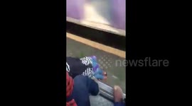 Girl slips nearly fall on to tracks, pulled back by fellow commuters in India