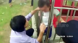 Toddler gets head stuck in railings at a park in China