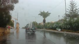 Pickup truck carrying a ladder in a dangerous manner.