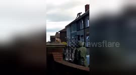 Newsflare Edit - Half naked man on roof throws tiles at police