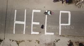 Indonesians chalk 'HELP' on ground as officials say search for victims to end