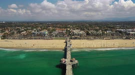 Drone flight over the pier in Huntington beach California, with a view of the beach