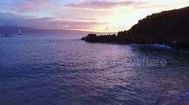 Drone flight over Kaanapali beach in Maui Hawaii at sunset.