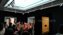 People trying to get a good shot of Banksy's shredded artwork
