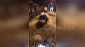 Men go wakeboarding on flooded road after monsoon rains