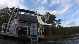 Dog going down water slide on a houseboat.