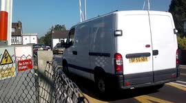 Van stops under level crossing barrier and has to reverse